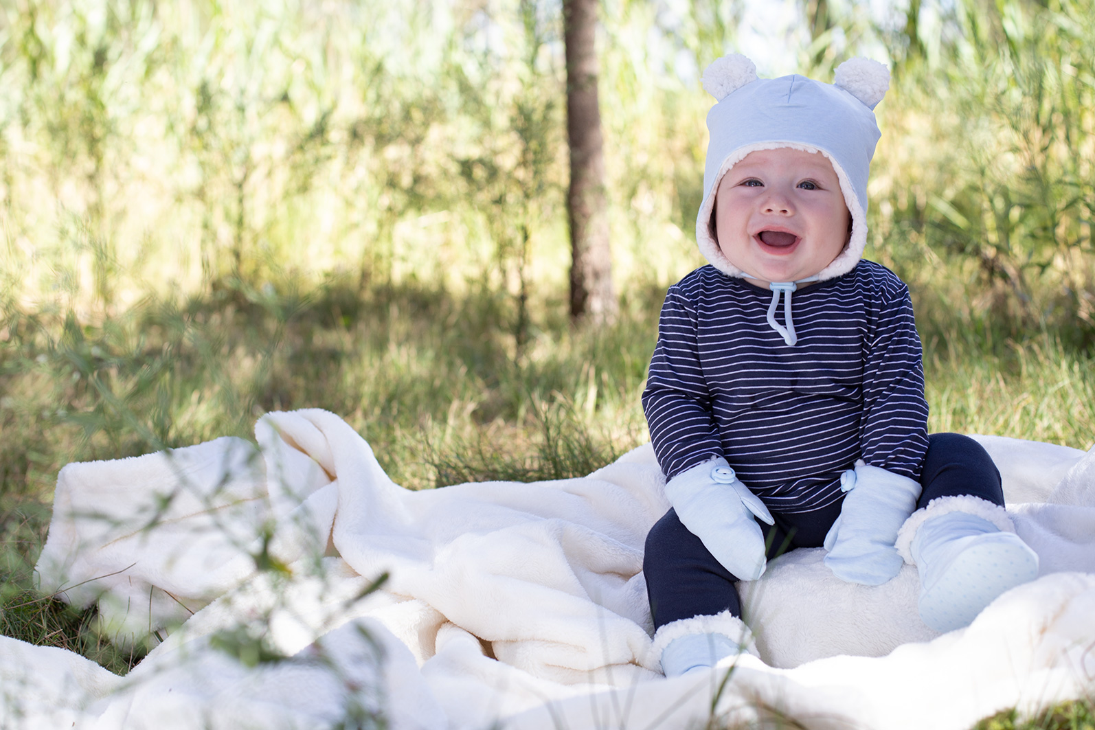 Baby wearing Bedhead beanie, mittens and booties in baby blue marle