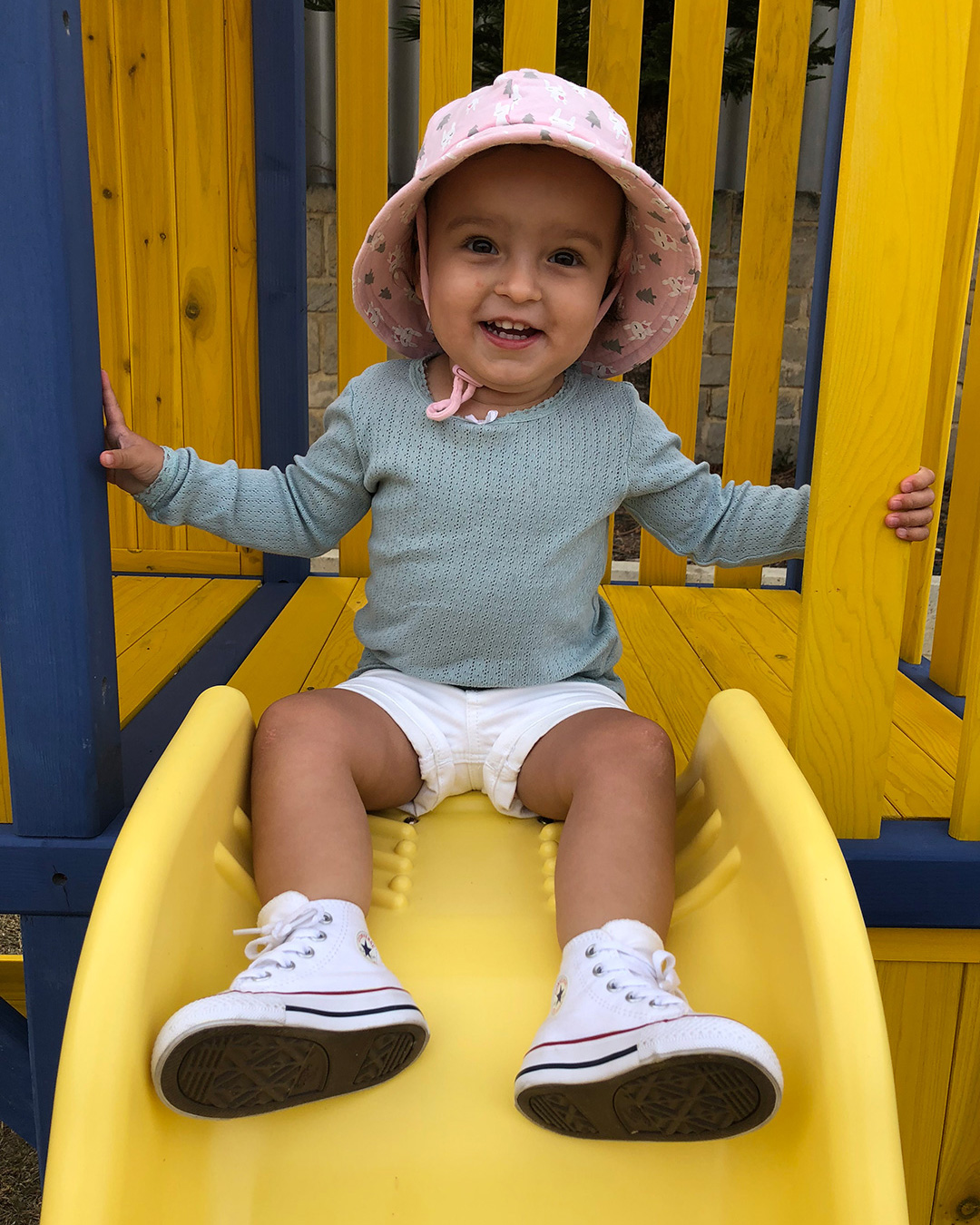 Toddler on slippery dip wearing Bedhead Baby Bucket 'Bunny' Print