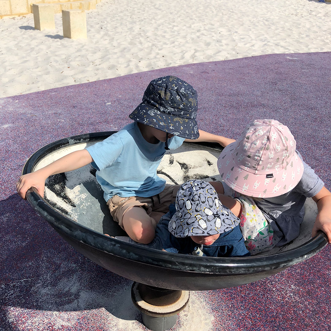 Siblings wearing Bedhead Hats at the playground