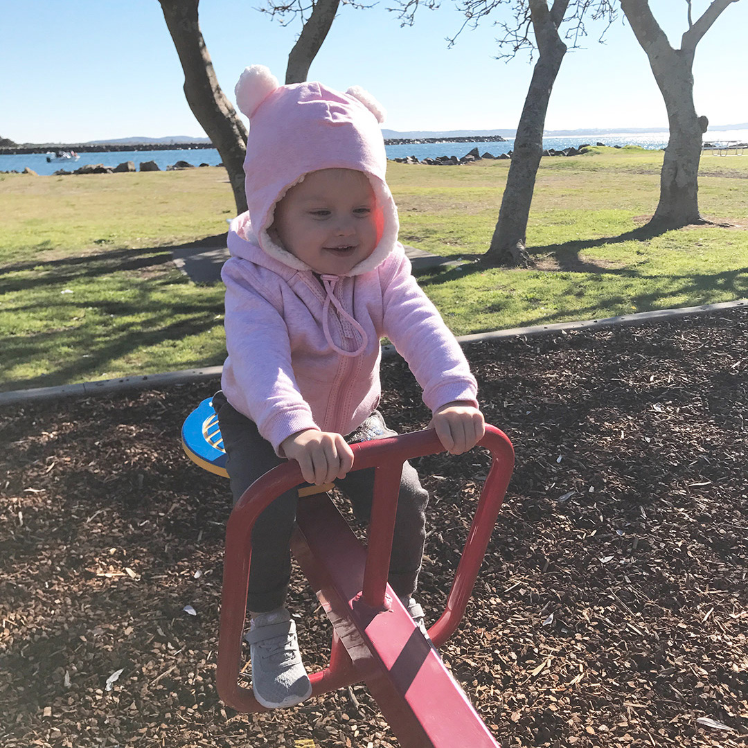 Toddler girl on sea-saw in Bedhead Teddy Beanie Baby Pink Marle