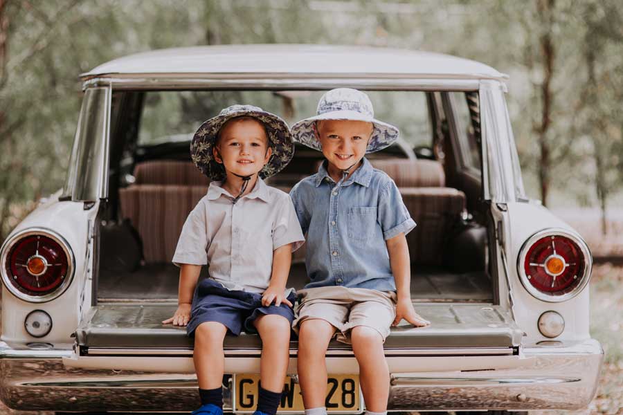 Heritage boys sitting on car